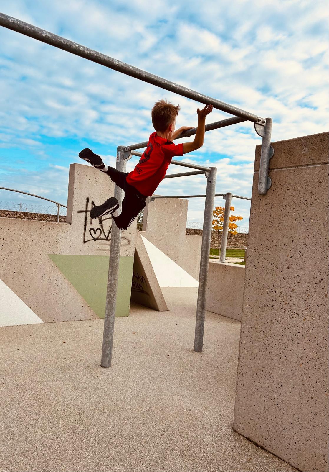 Henri auf dem Parkour-Gerüst beim Hangeln